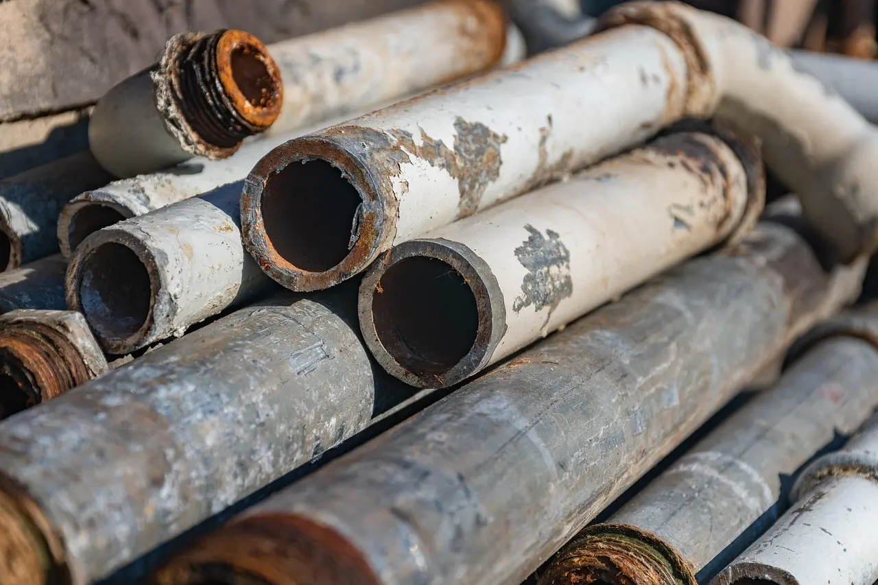 Tuyaux et tubes d'acier usagés empilés, retirés d'un chantier ou d'une usine